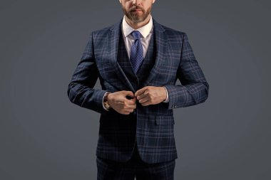 Gri üzerine kravat takılmış resmi takım elbise ceketi. İş adamı ceketli adam. İş elbisesi. Resmi erkek giyim konsepti. Formalite icabı giyinmiş bir adam. Zarif takım elbiseli bir iş adamı. Takım Elbise Kumaşı.