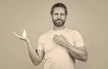 Burun tıbbı damlaları olan bir adam görüntüsü. Burun tıbbı olan adam sarıda izole edilmiş. Geçmişinde burun tıbbı olan bir adam. Stüdyoda burun tıbbı olan bir adam..