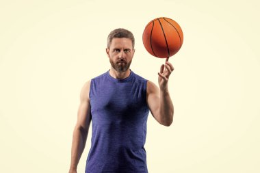 Basketbol topuyla oynayan bir adam. Profesyonel basketbolcu eğitimi beyazda izole edilmiş. Kaslı adamın spor motivasyonu var. Spor ve hobi. Basketbolcu adam profesyonel oynuyor. Maç günü.