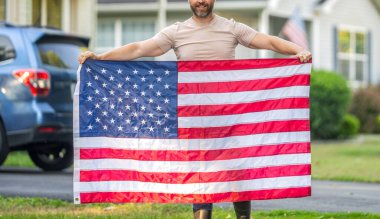 Adam Amerikan bayrağını dışarıda tutuyor. Vatanseverlik sembolü olan bir vatansever. Amerikan bağımsızlığı. Ulusal bayrak. Bağımsızlık Günü. Bağımsızlık Günü için Amerikan Bayrağı ya da 4 Temmuz. Kırpılmış görünüm.