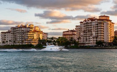 Fisher Adası gün batımı. Lüks motorlu tekne yatı. Yat marinaya gidiyor. Tekne ve yat gezisi. Lüks bir yaşam tarzı. Fisher Adası 'nda lüks bir binada yat. Yaz tatili.
