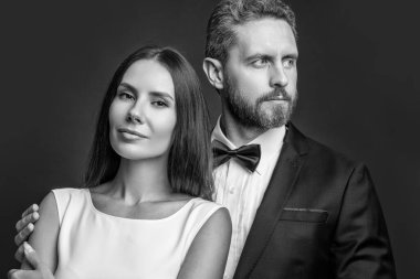 Yıldönümü portresi. Sevgililer Günü vesilesiyle. Resmi çift. Resmi kıyafetli bir çift. Lüks takım elbiseli kadın ve erkek. Zarif bir tarz randevusu. Kırmızıda soyutlanmış zarif bir erkekle romantik bir kadın. Birbirine aşık çift.