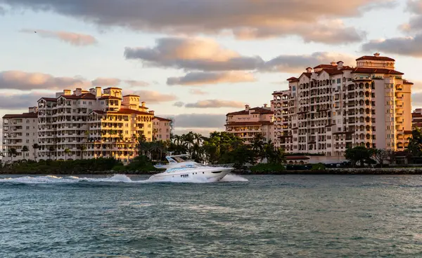 Fisher Adası gün batımı. Lüks motorlu tekne yatı. Yat marinaya gidiyor. Tekne ve yat gezisi. Lüks bir yaşam tarzı. Fisher Adası 'nda lüks bir binada yat. Yaz tatili.