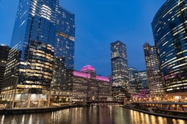 Nehirdeki Chicago gökdelenin mimarisi. Şehir gecesi aydınlatılmış bina. Gökdelen şehir manzarası. Chicago, Illinois 'de bir gece şehri. İş şehri. Chicago gökdelen binasının gece manzarası.