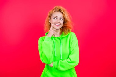 Modayla ilgilenen kız modaya uygun ve parlak görünüyor. Pembe kapüşonlu bir kadın. Moda modeli. Şık kapüşonlu kızıl saçlı kız. Sıradan kapüşonlu, şık, beyaz bir kadın. Çabasız bir şekilde şık..