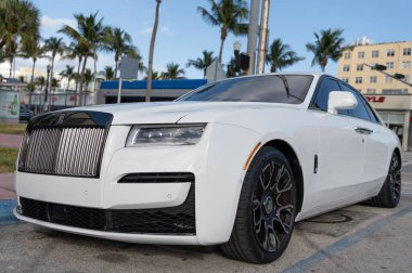 Miami, Florida, ABD - 12 Aralık 2024: Beyaz Rolls Royce Hayalet 2021 sedan araba. Rolls Royce Hayalet modelinin lüks sedan arabası. Rolls Royce 'un arabası dışarıda park edilmiş. Rolls Royce, ön manzara..