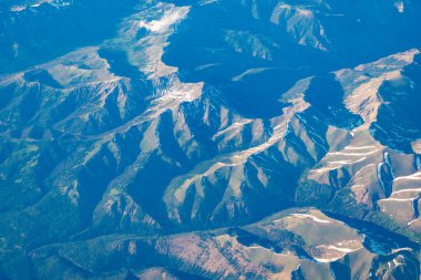 Uçaktan dağa. Dağlı, bulutlu bir manzara. Bulut ve dağ zirvesi hava manzarası. Doğa geçmişi. Dağ manzarasının havadan görünüşü. Hava bulutlu manzara görüntüsü.
