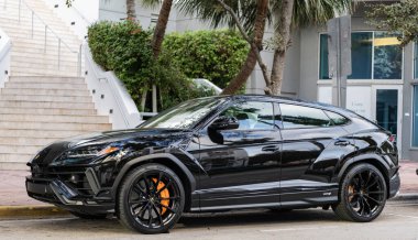 Miami, Florida, ABD - 08 Aralık 2024 Lamborghini Urus S SUV spor yara izi. Lamborghini Urus S tipi lüks bir spor araba. Lamborghini Urus 'un arabası dışarıda park edilmiş. Siyah Lamborghini Urus, yan görünüm.