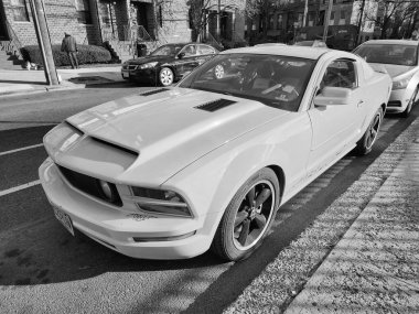 New York City, ABD - 18 Mart 2024: Ford Mustang GT coupe sarı açık hava, köşe manzaralı.