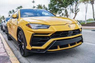 Miami, Florida, ABD - 15 Aralık 2024: Sarı Lamborghini Urus 2019 SUV arabası. Lamborghini Urus tipi lüks bir araba. Lamborghini Urus 'un arabası dışarıda park edilmiş. Lamborghini Urus, köşe manzaralı..
