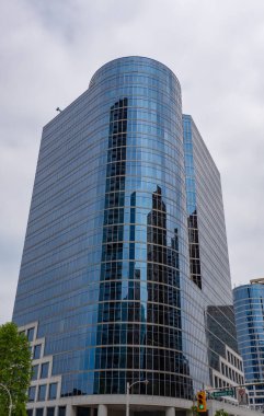 Gökdelen mimarisi. Camdan yapılmış bir gökdelen. Modern cam bina. Şehir merkezindeki gökdelen. Şehir hayatı. Şehir merkezinde gökdelenli. İş bölgesindeki ofis binası.