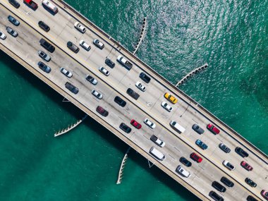 Broad Causeway Köprüsü Biscayne Körfezi boyunca uzanıyor. Liman Koyu Adaları 'nı Miami' ye bağlayan şehir yolu. Geçidin üst hava manzarası. Key Biscayne Köprüsü. Arabalar geçerken köprü çiz.
