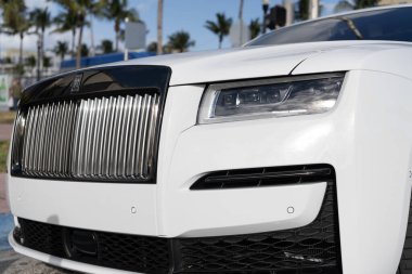 Miami, Florida, ABD - 12 Aralık 2024: Beyaz Rolls Royce Hayalet 2021 sedan araba. Rolls Royce Hayalet modelinin lüks sedan arabası. Rolls Royce 'un arabası dışarıda park edilmiş. Rolls Royce, ışık manzaralı..