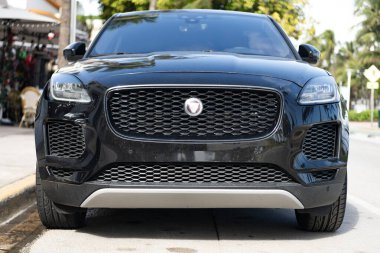 Miami, Florida, ABD - 17 Aralık 2024: 2018 Jaguar E-PACE geçiş aracı. Jaguar E-PACE tipi lüks bir araba. Jaguar 'ın arabası dışarıda park edilmiş. Jaguar siyah rengi, ön görünüm.