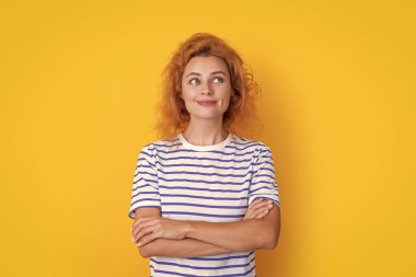 Düşünceli kızıl saçlı kadın yüzü sarı arka planda izole edilmiş. Stüdyodaki genç kızıl saçlı kadının yüzü. Yetişkin kızıl saçlı kadın yüzü.