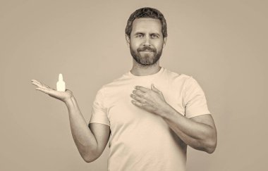 Burun tıbbı damlaları olan bir adam görüntüsü. Burun tıbbı olan adam sarıda izole edilmiş. Geçmişinde burun tıbbı olan bir adam. Stüdyoda burun tıbbı olan bir adam..