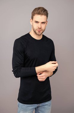 Sıradan erkek tarzı. Beyazlı genç bir adam gri yolda izole edilmiş. Kendine güvenen adam portresi. Erkeklerin cilt bakımı. Erkek derisi. Adamın şık bir saç kesimi var. Moda saç stili olan bir adam. Sıradan havalı..