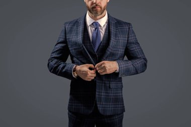 Gri üzerine kravat takılmış resmi takım elbise ceketi. İş adamı ceketli adam. İş elbisesi. Resmi erkek giyim konsepti. Formalite icabı giyinmiş bir adam. Zarif takım elbiseli bir iş adamı. Takım Elbise Kumaşı.