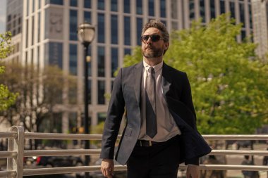 Profesyonel CEO. Takım elbiseli bir iş adamı. Zengin adam kostümü ofise yürür. Üst düzey yönetici. Şehrin kendine güveni tam patronu. Finansal başarı. İş adamı dışarı çıktı. Şehir sokaklarında iş adamı..