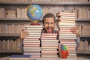 Ders kitabı olan inek bir adam. Okul edebiyat eğitimi. Sınıftaki inek adam. Okul kütüphanesinde kitap kurdu. Eğitim ve bilgi. Sınıftaki erkek öğretmen. Okul eğitimi. Okuma alışkanlıkları.