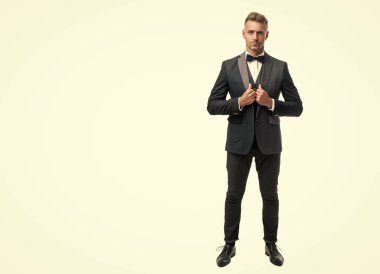 Smokin papyonlu hırslı adam beyaz arka planda izole edilmiş. tam uzunluk.