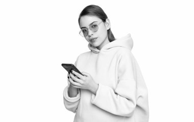 Modern milenyum kızı, günlük pembe kapüşonlu ve gözlüklü beyaz telefon kullanıyor..