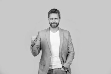 Gülümseyen yakışıklı adamın resmi. Takım elbise giyiyor. Resmi ceket giyen bir adam. Sarı arka planda yalıtılmış beyaz ceketli bir adam. Stüdyoda adam.