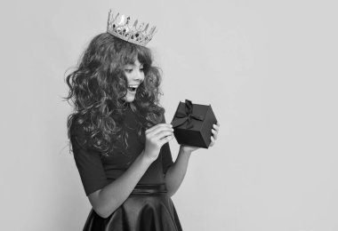 Sarı arka planda mevcut kutusuyla taç giymiş şok bir çocuk..