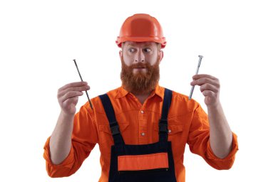 Tamirci. Adam çekiç çivisi tutuyor. Marangozluk tamir ve çekiç. Üniformalı tamircinin çivisi var. Sakallı marangoz çivi tutar. Marangoz, çivi beyazı ile onarıyor. İnşaat ve çerçeve.