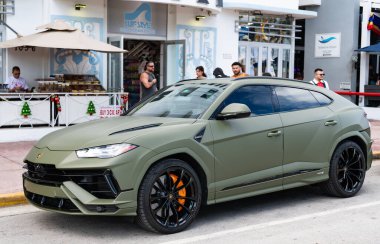 Miami, Florida, ABD - 08 Aralık 2024: Luxur yeşil renkli Lamborghini Urus S tipi spor araba. Lamborghini Urus 'un arabası dışarıda park halinde. Lamborghini Urus, köşe manzaralı. 2024 Lamborghini Urus S SUV arabası.