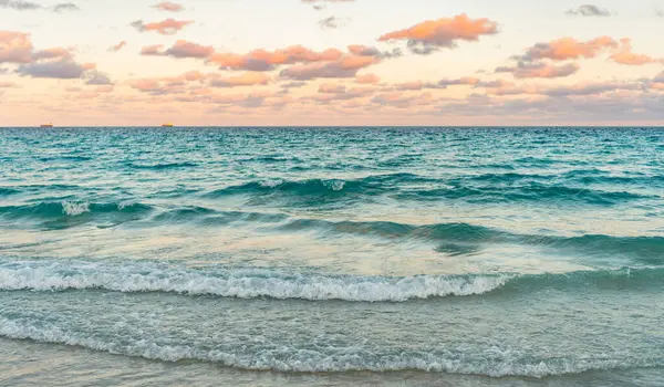 Deniz doğarken sakin ufuk manzarası. Deniz manzarasında romantik yaz tatili gündoğumu. Deniz ufku manzarası. Yaz tatilinde bulutlu gökyüzü ve deniz manzarası. Deniz ufkuyla gökyüzü. Ufukta gün batımı.