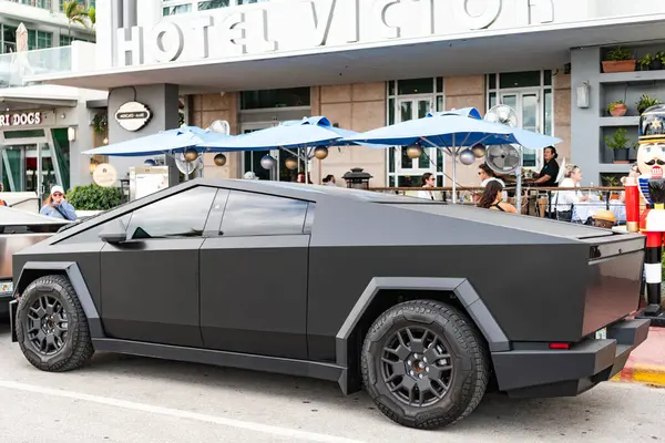 Miami, Florida, ABD - 06 Aralık 2024 Tesla Cybertruck elektrikli kamyonet vagonu. Tesla Cybertruck 'ın siyah elektrikli arabası. Tesla Cybertruck 'ın arabası dışarıda park edilmiş. Tesla Cybertruck, yan görüş.