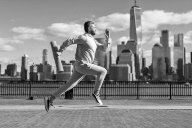 Sporcu adam aktif giyinmek için koşuyor. Sporcu koşucu. Manhattan 'da spor habercisi. New York 'a doğru koşan sporcu. Fiziksel aktivite.