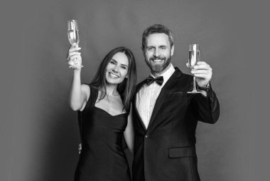 Zarif çift kırmızıda izole edilmiş şampanya içer. Resmi olarak bir çift. Romantik randevu kutlamaları. Sevgililer Günü. Yıldönümünü kutlayalım. Aşık çift nişanı kutluyor. Şerefe..