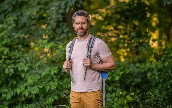 Erkek doğa yürüyüşçüsü. Sırt çantalı bir gezgin. Yürüyüş macerası ve seyahat tutkusu. Seyahat yaşam tarzı. Kırsalda yürüyüş yapan bir adam. Ormandaki İspanyol adam. Sırt çantalı bir yürüyüşçü ormanda yürüyüş yapıyor..