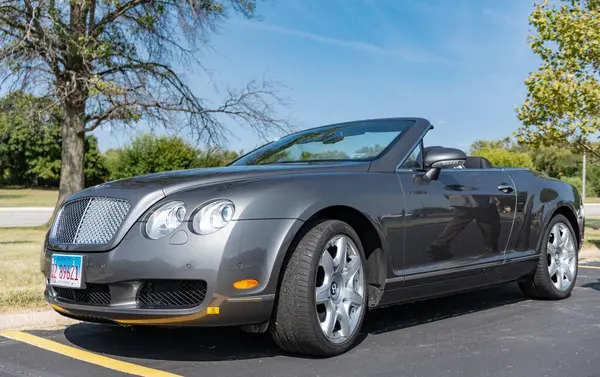 Chicago, Illinois, ABD - 08 Eylül 2024: 2007 Bentley Continental GTC üstü açık araba, köşe manzaralı. Lüks gri bir araba. Bentley Continental GTC arabası. Metalik gri Bentley Continental GTC 'de