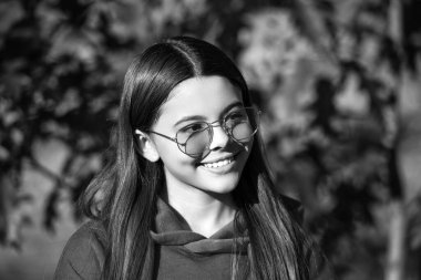 Sonbahar sezonu. Kız sonbaharda rüya görür. Gençlik modelinin sonbahar havası. Dışarıdaki parkta sonbahar yaprakları. Kız portresi. Sonbahar kızı güneş gözlüğü takıyor ve şık görünüyor. Mevsimsel değişim.