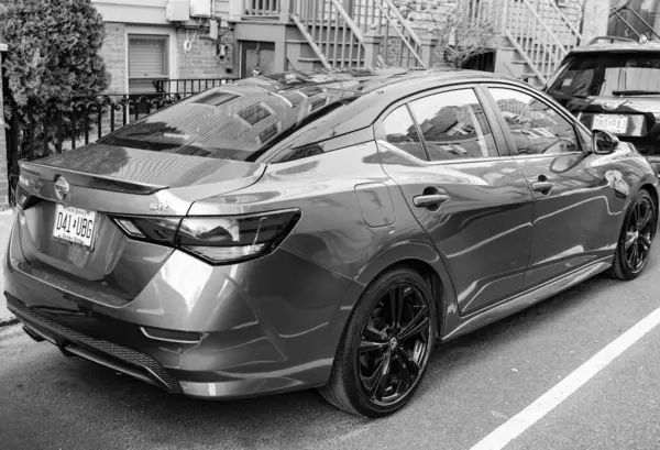 New York City, ABD - 26 Mart 2024 Nissan Sentra turuncu modern araba açık havada, köşe manzaralı.