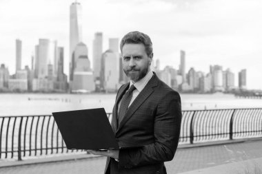 New York 'ta serbest çalışan bir iş adamı. İnternette çalışan bir iş adamı. İş adamı dışarıda bilgisayar ya da dizüstü bilgisayarda çalışmakla meşgul. Adam internet tarayıcısından iş e-postası ve sörf yolluyor. Piyasa talebi.