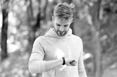 Spor kıyafetleri giymiş bir adamın spor izleme sonuçları. Fitness aleti olan bir koşucu. Fitness için akıllı seğirme. Spor ekipmanlı, formda bir adam akıllı sette zamanı kontrol ediyor. Çalışma zamanını kontrol et.