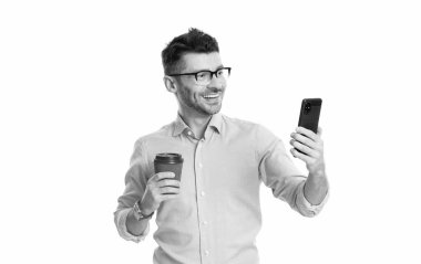 İş adamı iletişim için telefonu kullanıyor. Kahveli bir iş adamı beyazın üstüne izole edilmiş. Kahve molası. İş iletişimi. Adam iş konuşuyor. Telefon var. İletiyi temizle.