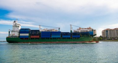 Konteyner gemisi. Konteynırlı kargo gemisi. Yük konteynırı kargo gemisine yüklendi. Limandan ayrılan ya da limana giren kargo gemisinin görüntüsü. Kargo işi..