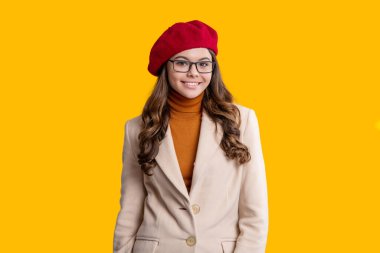 Moda ve şık bir genç kız. Gençler için sonbahar moda tarzı. Sonbahar tarzının modaya uygun portresi. Sonbahar montlu kız sarıda soyutlanmış. Genç kız ceket giyiyor. Sonbahar moda kızı. Lüks kumaşlar.