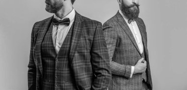 Smokinli adamlar resmi kıyafet giyerler. Papyonlu, erkek giyimli şık erkekler. İş etkinliğindeki iki iş adamı. Smokinli adamlar Griler 'de izole edilmiş. Formalite icabı smokin giyen adamlar. Kırpılmış görünüm.
