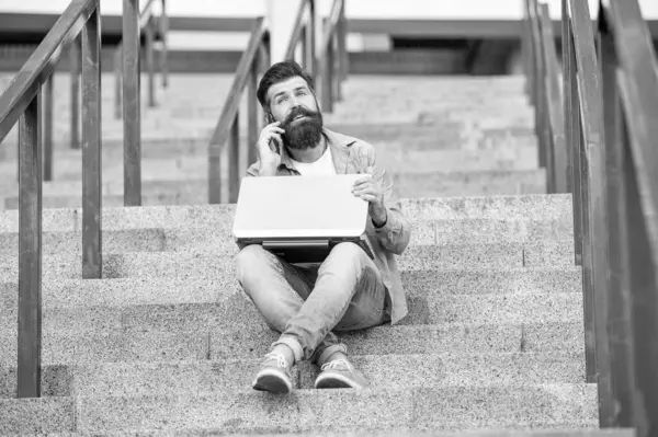 Adamın dış mekanda görüntülü iletişimi var. Adamın dışarıda çevrimiçi video bağlantısı var. Adamın merdivenlerde online video bağlantısı var. Adamın online video iletişimi var.