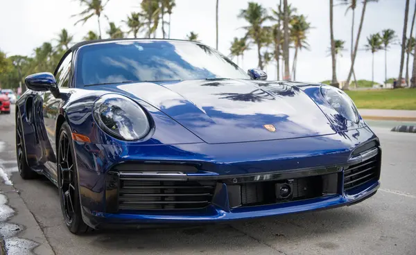 Miami, Florida, ABD - 15 Aralık 2024: Mavi Porsche 992 üstü açık spor araba. Üstü açık Porsche 992 model lüks spor araba. Porsche 992 'nin arabası dışarıda park edilmiş. Porsche 992, ön manzara..