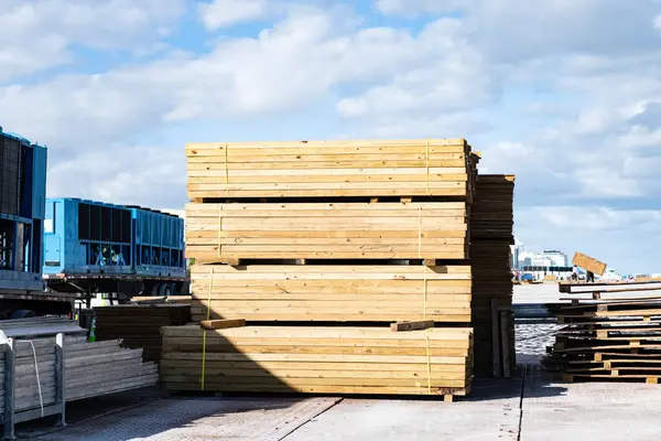 Dışarıdaki ahşap malzeme deposu. İnşaat alanında kereste ve kereste endüstrisi. Ahşap yapı malzemesi. Kereste ve kerestelerle inşaat alanı deposu. Endüstriyel malzeme.