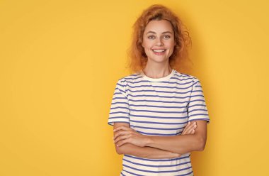 Sarı arka planda izole edilmiş, fotokopi alanı olan mutlu kızıl saçlı kız portresi. Stüdyodaki genç kızıl saçlı kızın portresi. Yetişkin kızıl kız portresi.