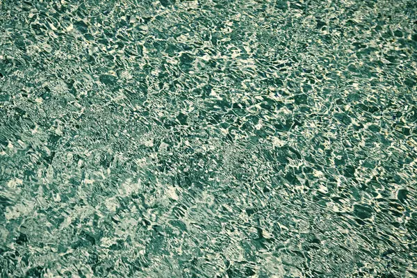 Yüzme havuzu suyunun turkuaz renk arkaplanı. Yaz konsepti.