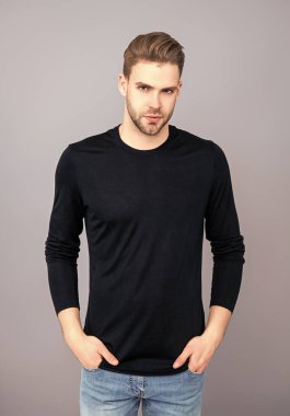 Kendine güvenen adam portresi. Erkeklerin cilt bakımı. Erkek derisi. Adamın şık bir saç kesimi var. Moda saç stili olan bir adam. Sıradan erkek tarzı. Beyazlı genç bir adam gri yolda izole edilmiş. Kaba ve yakışıklı..